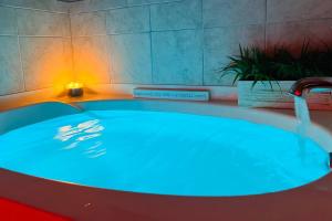 a hot tub with a blue light in a bathroom at Varona's Paradise: Stunning New Luxury Home. in Lake Charles