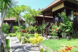 a house with a garden in front of it at Perdana Homestay Lembongan in Nusa Lembongan