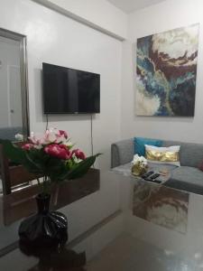 a living room with a vase with flowers on a table at Adel's Haven in Camella Northpoint in Davao City
