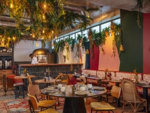 a restaurant with tables and chairs and a chef in the background at La Belle Ville in Paris