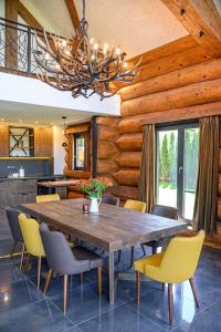 a dining room with a wooden table and chairs at Alpina Luxury Chalets in Banya