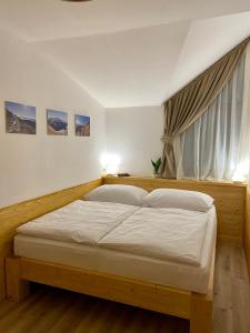 ein Schlafzimmer mit einem großen Bett vor einem Fenster in der Unterkunft Apartmány Jasná, Biela Púť in Demänovská Dolina