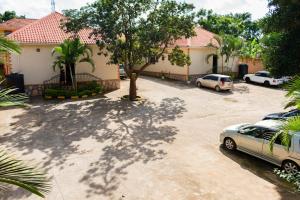 een parkeerplaats met auto's geparkeerd voor een huis bij Etana Motel Kampala in Kampala