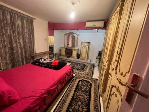 a bedroom with a red bed and a mirror at Family Apartment in Nasr City in Cairo