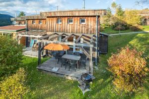 einen Blick über ein Haus mit einer Terrasse mit einem Sonnenschirm in der Unterkunft Feriendorf Tauerngast in Hohentauern