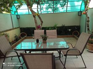a glass table and chairs in a patio at Safe & Cool Apartment in Heraklio Town