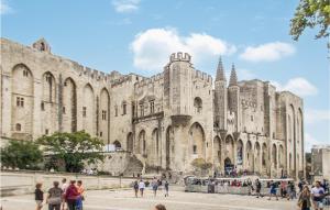 ein großes Steingebäude mit Menschen, die um ihn herum laufen in der Unterkunft 2 Bedroom Gorgeous Apartment In Avignon in Avignon + 15 Fotos