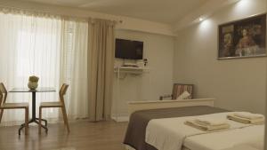 a bedroom with a bed and a table and a tv at City Class Accommodation in Zadar