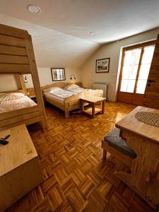 a bedroom with two bunk beds and wooden floors at Guesthouse Smogavc in Zreče