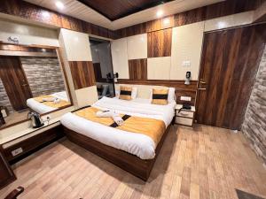 una camera con un grande letto e uno specchio di Hotel Victory a Shimla