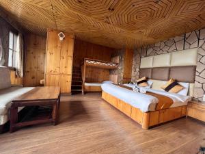 a bedroom with two beds and a wooden ceiling at Hotel Victory in Shimla