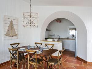 a kitchen and dining room with a wooden table and chairs at Case Li Conchi G in Castiadas