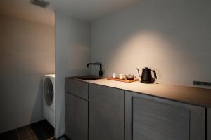 a kitchen with a counter with a sink and a washing machine at SGR鴨川 in Gionmachi