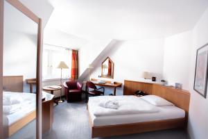 a hotel room with two beds and a desk at Hotel Zumnorde Am Anger in Erfurt