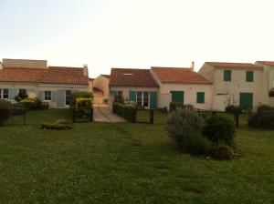 a row of houses in a yard with green grass at Maison La Flotte face à la mer in La Flotte