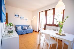 a living room with a white table and a blue couch at Le Vele Beth's House in Brenzone sul Garda