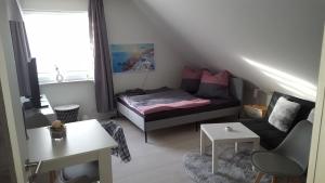 a small living room with a bed and a couch at Kleine Oase bei Nina in Zorge