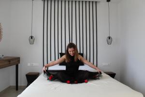 a woman sitting on top of a bed at LEMONIA STUDIOS&SUITES in Agia Anna Naxos