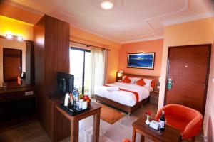 ポカラにあるHotel Task Internationalのベッドとテレビが備わるホテルルームです。