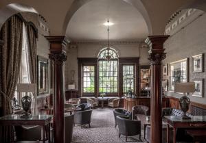 a large room with chairs and tables and windows at Crathorne Hall in Yarm