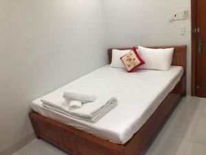 ホーチミン・シティにあるKhách sạn Huy Phươngのベッド(白いシーツ、タオル付)