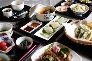 una mesa con platos de comida y tazones de comida en Ryokoji Temple, en Minami Aso