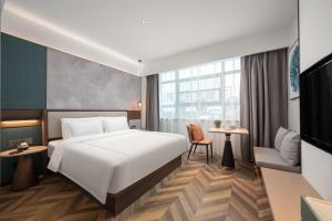 um quarto de hotel com uma cama e uma televisão em 银座佳悦精选酒店冠县冠宜春路店 em Kwanhsien
