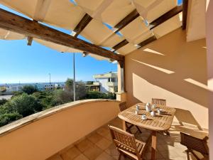 patio con mesa de madera y sillas en el balcón en Torre Pali House, en Torre Pali