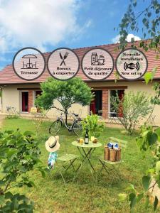 una mesa de picnic frente a un edificio con carteles en Logis Hôtel du Château, en Tour-en-Sologne