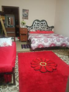 a bedroom with two beds and a red carpet at Furnished room just 1 minute to Al ain mall in Al Ain
