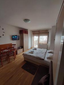 ein Schlafzimmer mit einem großen Bett und einem Tisch in der Unterkunft Zlatibor Apartman 69 in Zlatibor