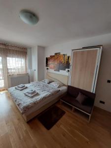 ein Schlafzimmer mit einem Bett und einem Stuhl darin in der Unterkunft Zlatibor Apartman 69 in Zlatibor