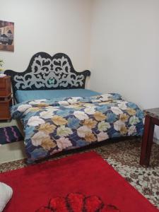 Bett in einem Zimmer mit einem roten Teppich und einem 6-dx-dx-Bett. in der Unterkunft Furnished room just 1 minute to Al ain mall in al-Ain