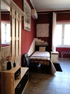une chambre avec un lit et une chaise dedans dans l'établissement Chloe's Rooms, à Cagliari