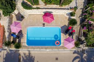 an overhead view of a swimming pool with pink umbrellas at Boutique B&B Villa Carmen in Mlini