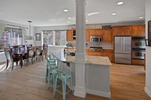 a kitchen with wooden cabinets and a kitchen island with chairs at Flagline Trail home in Bend
