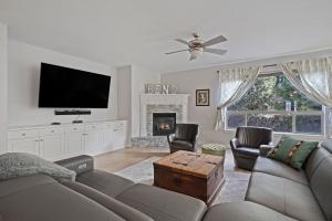 a living room with a couch and a tv and a fireplace at Flagline Trail home in Bend