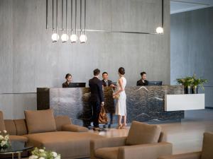 a group of people standing at a counter in a lobby at Fraser Residence Hanoi in Hanoi +113 photos