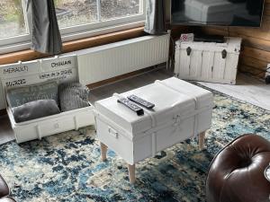een woonkamer met witte meubels en een televisie bij Sandra’s Gastenverblijf in Oostvoorne
