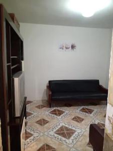 uma sala de estar com um sofá e piso em azulejo em Casa perto de tudo, pra você ter ótima experiência. Bora Conhecer Ouro Preto.... em Ouro Preto
