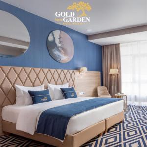 a bedroom with a bed with a blue wall at GOLD inn GARDEN in Krasnodar