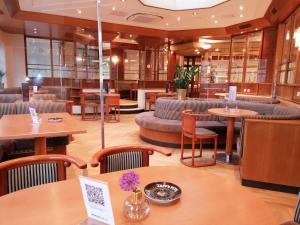 グロース・エンツァードルフにあるペンション ミュラー ガートナーのテーブル、ソファ、椅子が備わるレストラン
