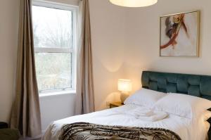 a bed in a room with a window and a bed sidx sidx sidx at Central Chic Margate Apartment, edge of Old Town! in Kent