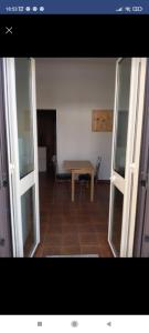 - Vistas a una habitación con mesa y puertas de cristal en La trinacria mare, en Messina