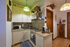 a kitchen with white cabinets and a sink at Casa di Mezzo "Historic centre of VARENNA" Lake Como in Varenna