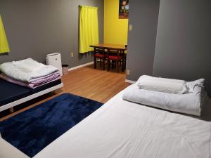 um quarto com 2 camas e uma sala de jantar com uma mesa em Naoshima Kowloon em Naoshima