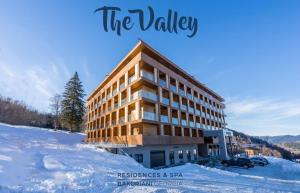 a building in the snow with the words the valley at Bakuriani the Valley 115 - 202 in Bakuriani