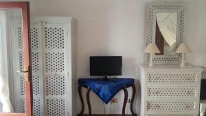 a room with a table with a tv and a mirror at Ianira - Le due Lune in Lampedusa