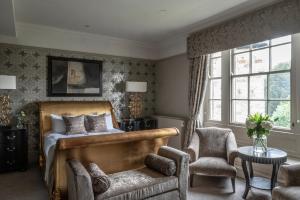 a bedroom with a bed and a chair at Wood Hall Hotel & Spa in Wetherby