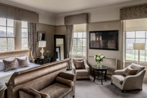 a bedroom with a bed and a couch and chairs at Wood Hall Hotel & Spa in Wetherby